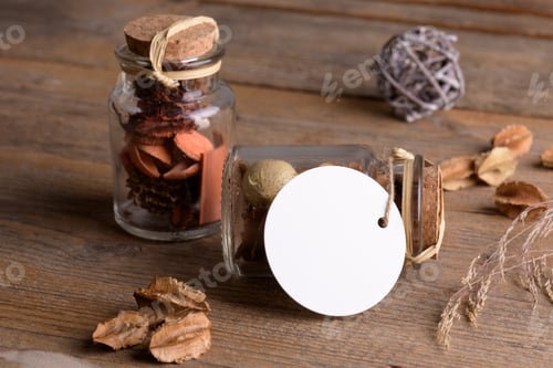 Preview: Round white tag mockup on glass jar with dry perfume a wooden background with boho decoration