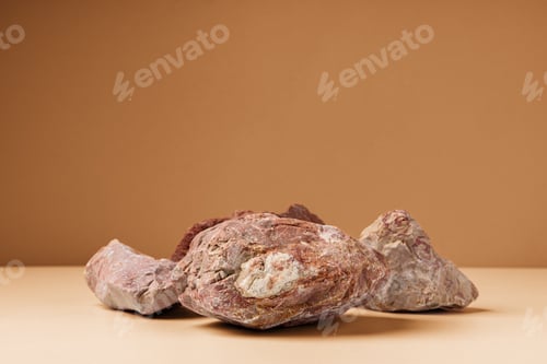 Preview: Piece of granite stone against beige background with shadows