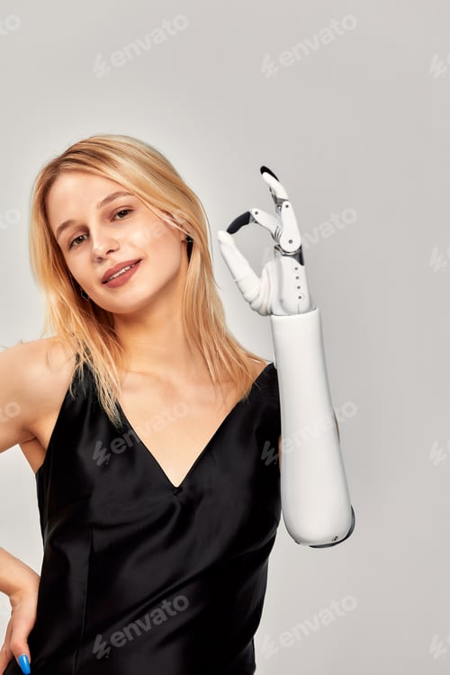 Preview: Studio portrait of beautiful young blonde girl with disability wearing sensory bionic prosthetic arm