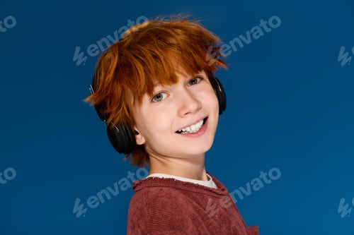 Preview: Vibrant redhead boy showcasing trendy child fashion in a cheerful studio setting