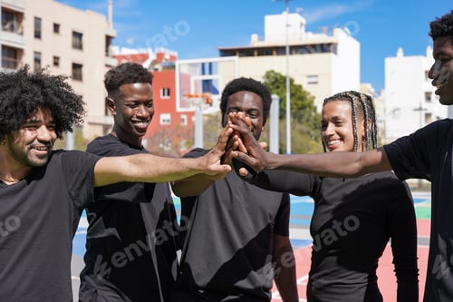 Preview: Group of young multiracial people stacking hands outdoor