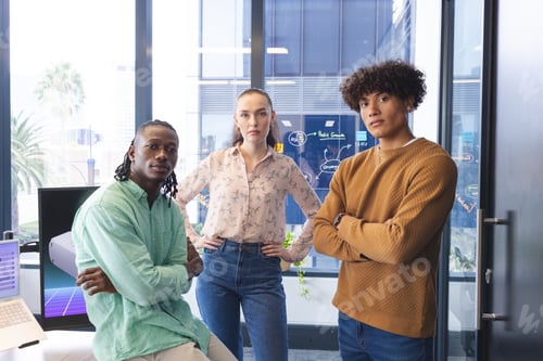 Preview: Diverse team standing in office, looking at camera