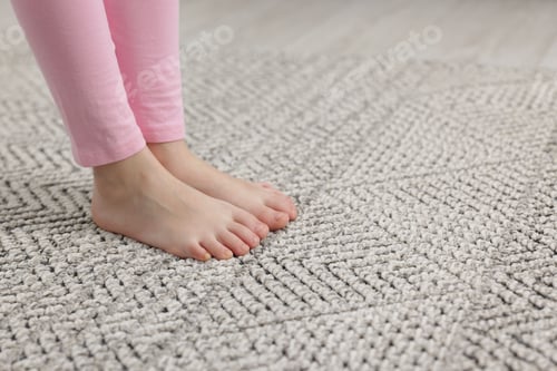 Preview: Girl on grey carpet at home, closeup. Space for text