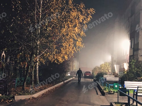 Preview: Man Walks Down Foggy Street at Night