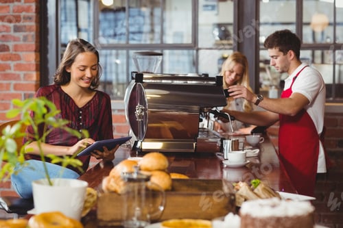 Preview: Handsome barista preparing a cup of coffee at the coffee shop