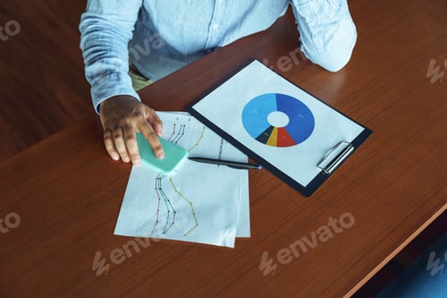 Preview: Close up of male analytic working with graphics and charts in office during working day