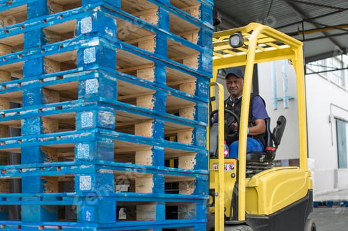 Preview: Forklift driver loading stacked pallets at packaging factory