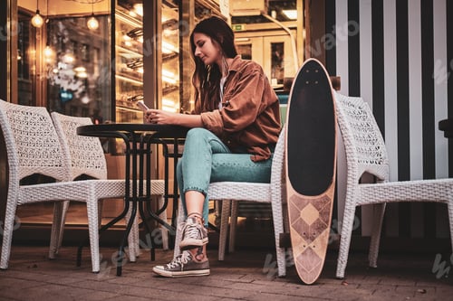 Preview: Girl is sitting near cafe with longboard