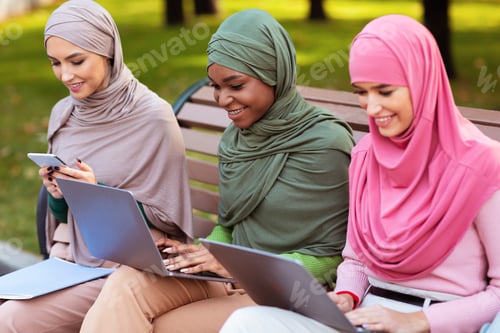 Preview: Muslim Students Women Using Gadgets Learning Online Sitting In Park