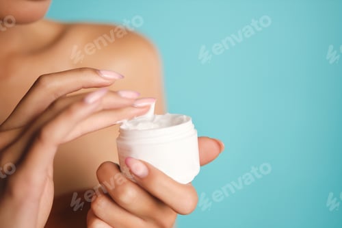 Preview: Close up young woman holding jar of beauty cream over colorful background