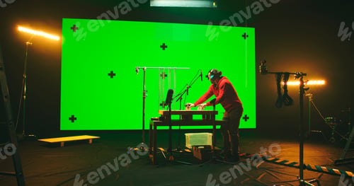 Preview: Man In Casual Clothes Recording Sounds On Table Under Microphones Against Large Screen With