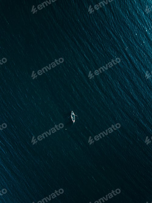 Preview: Aerial view of wooden fishing boat in deep blue sea.