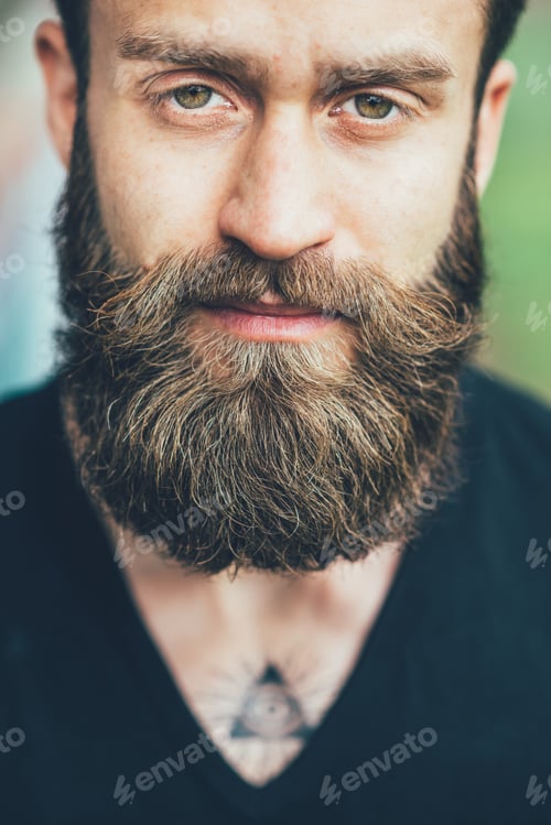 Preview: Portrait young bearded man loooking camera serious