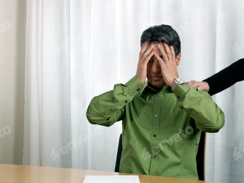 Preview: Business man by desk, hands on face