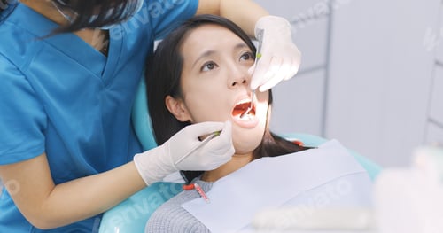 Preview: Woman checking her teeth in dental office