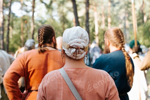 Preview: Back view of an unrecognizable woman with an ancient costume and a traditional scarf on her head