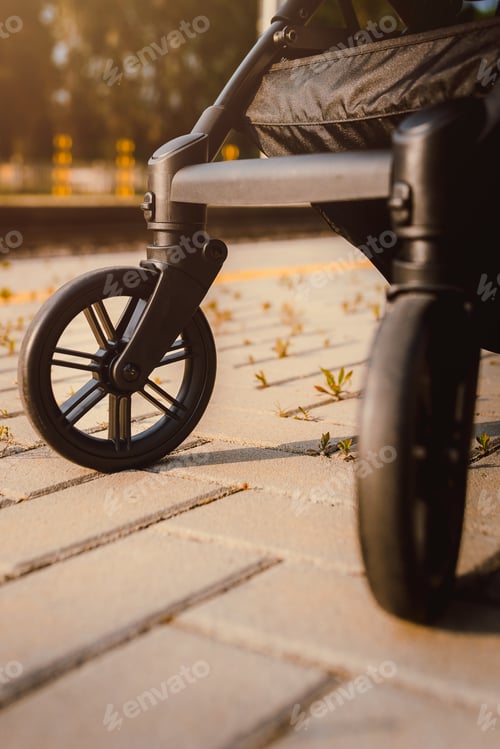 Preview: Close-up of stroller wheels at the train station at sunset.psd