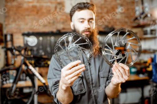 Preview: Repairman with break discs in the bicycle workshop