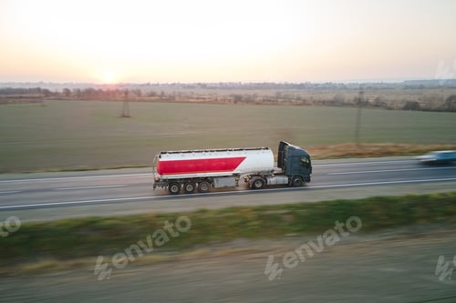 Preview: Aerial view of blurred fast moving fuel cargo truck driving on highway hauling goods. Delivery
