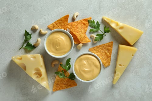 Preview: Cheese sauce and snacks on white textured table