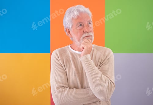 Preview: Adult bearded handsome senior man looking out standing over colorful cute background