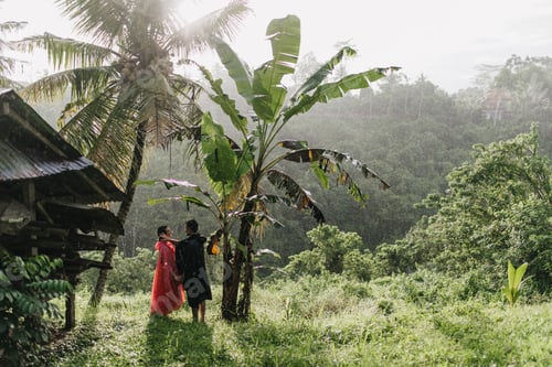 Preview: Full-length portrait of woman and man in raincoats. Outdoor photo of excited travelers looking at e