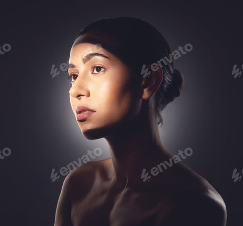 Preview: Studio shot of a beautiful young woman posing with light beam against her face