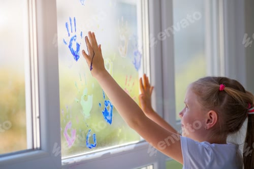 Preview: Children girl draw with palms on the window.