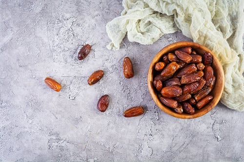 Preview: Dried date fruit in bowl on wooden background. Delicious dates fruit. Top view
