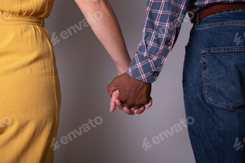 Preview: Close-up of the hands of a couple holding hands. Interracial couple, evolution of society