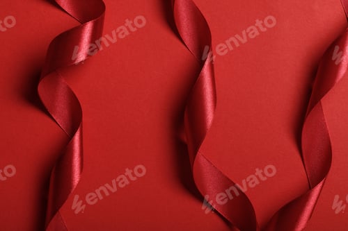 Preview: close up of curved silk red ribbons on red background