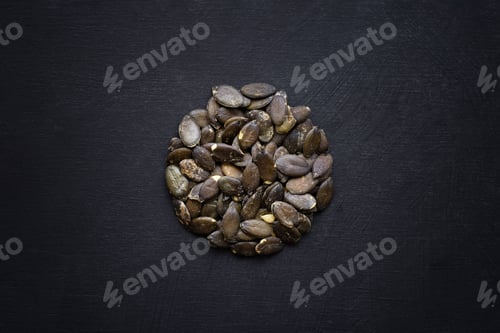 Preview: Top view of pumpkin seeds shaped as a circle on a black background