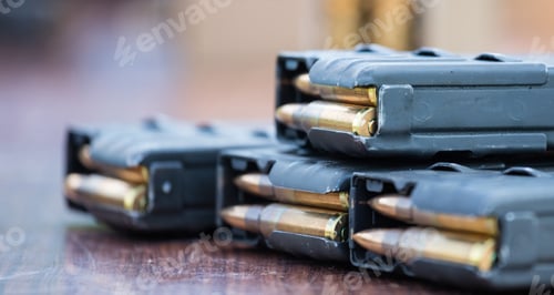 Preview: Magazines with bullets of firearm putted on wooden table. Close up view, blurred background.