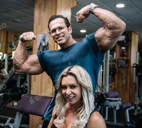 Preview: Man with arms raised showing his muscles with a girl sitting in front of him
