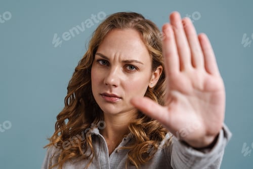 Preview: Displeased beautiful blonde girl showing stop gesture at camera