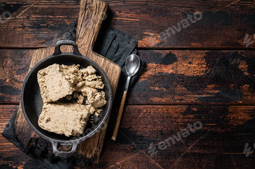 Preview: Halva with sunflower seeds and honey in pan. Wooden background. Top view. Copy space