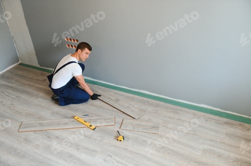 Aperçu: Homme posant un revêtement de sol stratifié dans un concept de construction