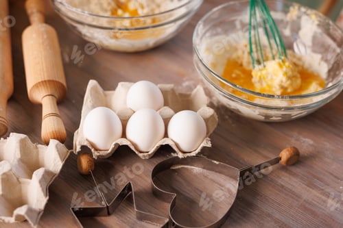 Preview: Kids baking cookies, mixing flour and eggs with kitchen utensils on a wooden table.
