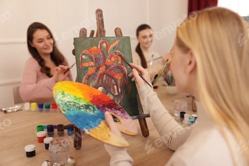 Preview: Group of women learning to draw at wooden table in class, focus on picture
