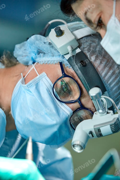 Preview: Close up portrait of female surgeon doctor wearing protective mask and hat during the operation
