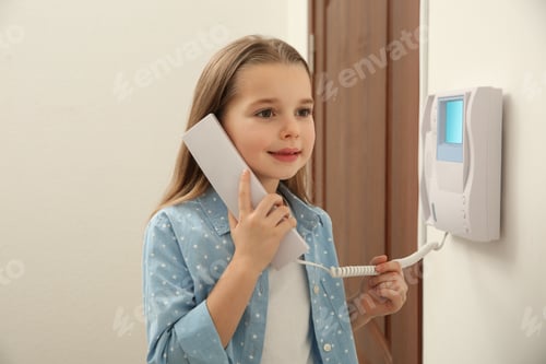 Preview: Cute little girl answering intercom call indoors