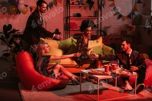 Preview: Young people celebrating with drinks in cozy room