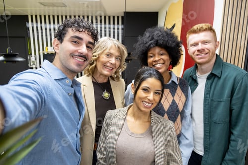 Preview: Diverse team taking a happy selfie in office