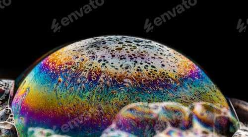 Preview: Closeup of soap bubble with rainbow colors on a dark background