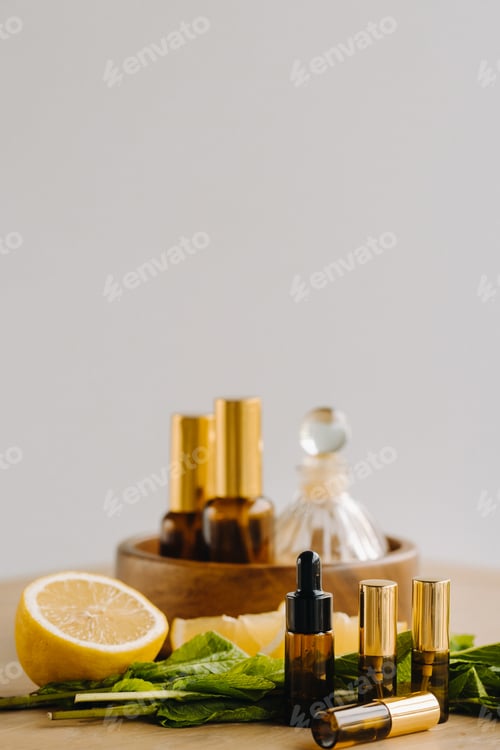 Preview: Essential oil in bottles with lemon and mint fragrance lying on a wooden surface
