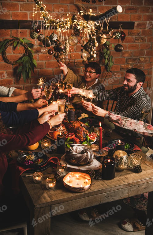 Preview: Family burning sparklers and feasting over Chtistmas holiday dinner table