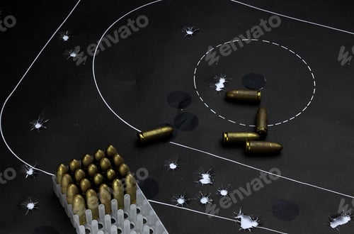 Preview: High angle shot of bullets on a target board - concept of military training or self-defense