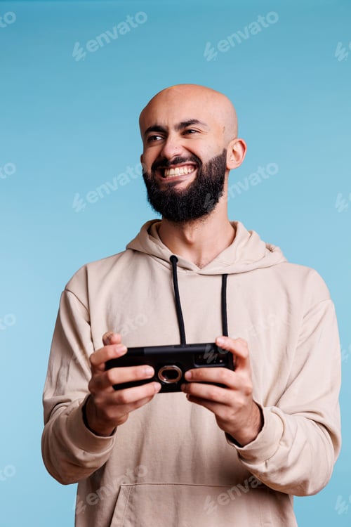 Preview: Arab man laughing, playing mobile game