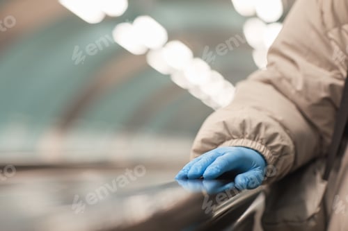 Preview: Hand in Blue Glove on Escalator Handrail