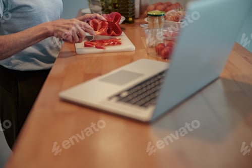 Preview: Senior woman chopping vegetables at home kitchen